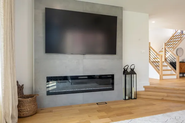 Great room with a linear fireplace and white oak floors in a renovated Margate, NJ home