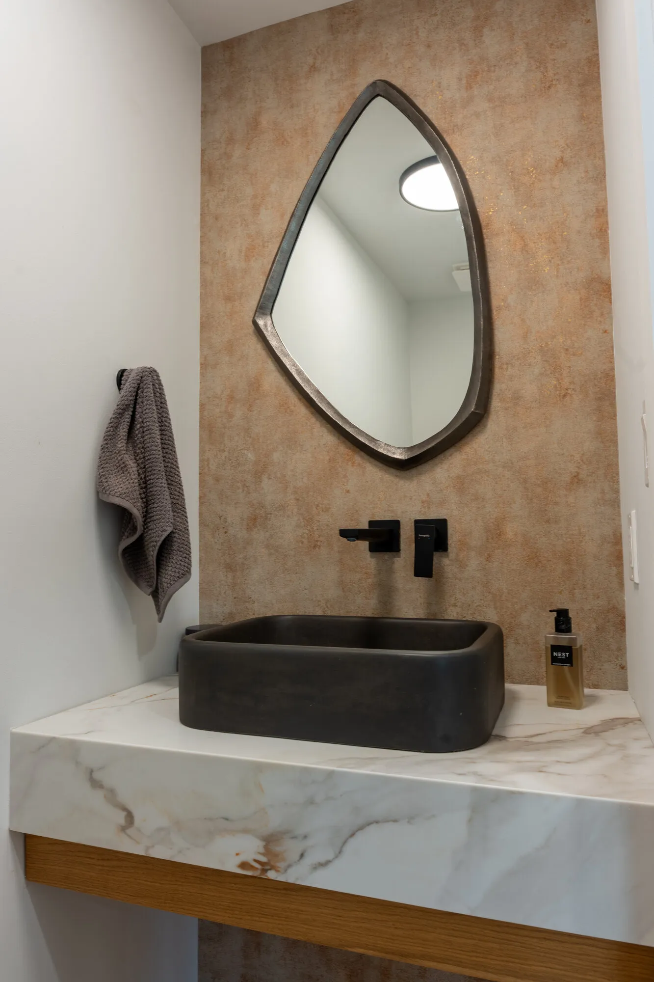 Powder room with a stone vessel sink and marble-look counter in Margate, NJ