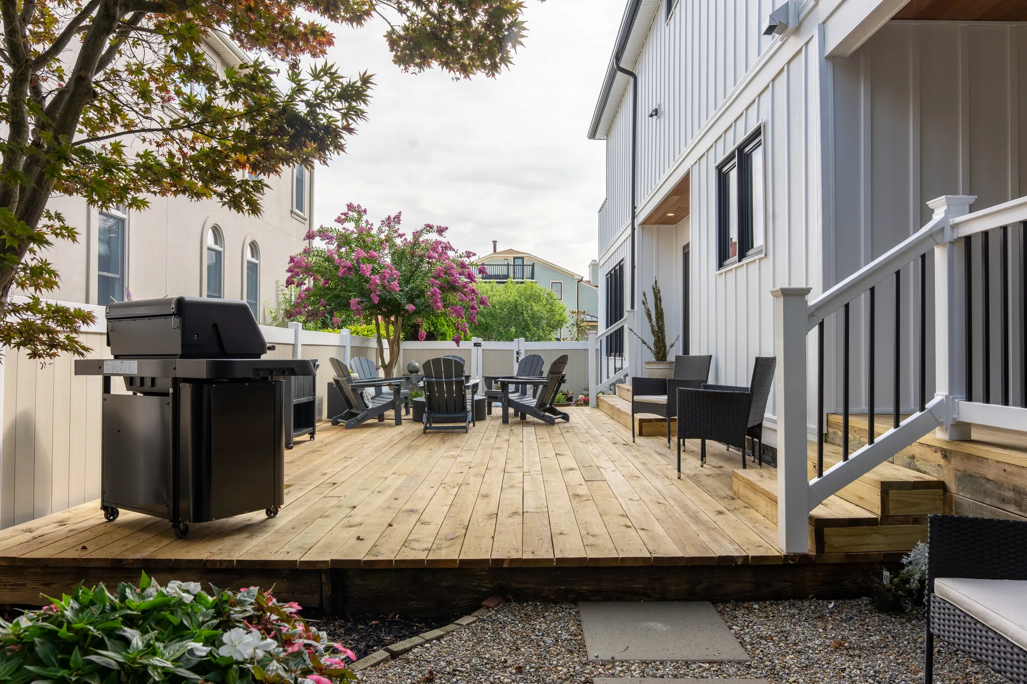 Rear deck with Adirondack seating and a grill, the outdoor living Seaboard builds on Jupiter waterfront lots
