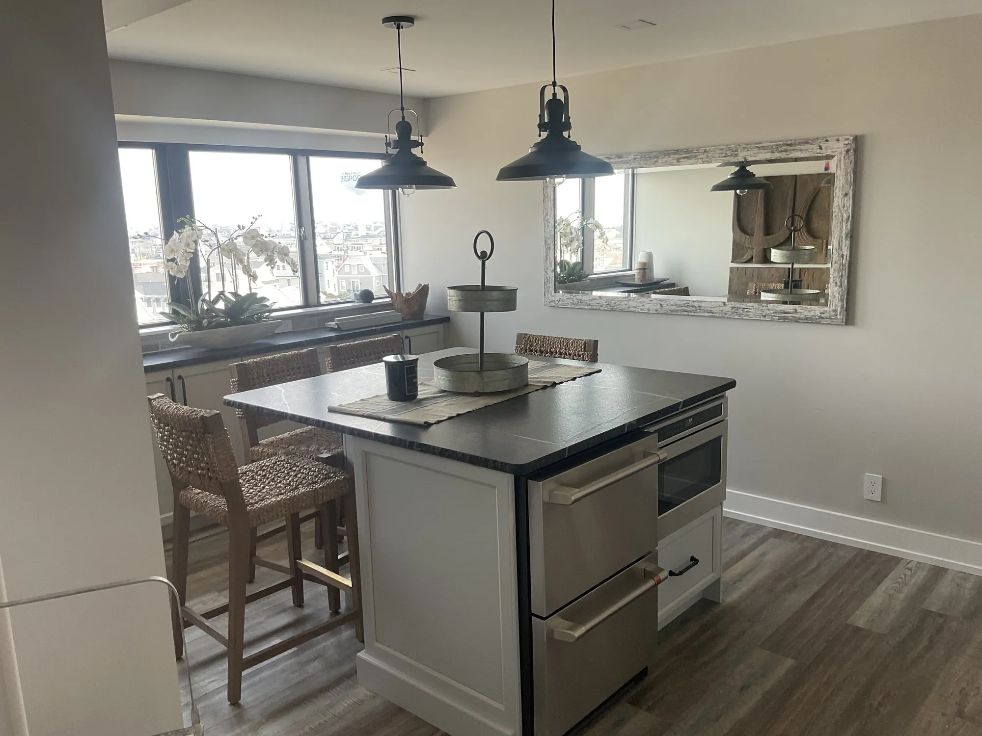 Kitchen island with a dark countertop, pendant lights, and water views in Longport, NJ