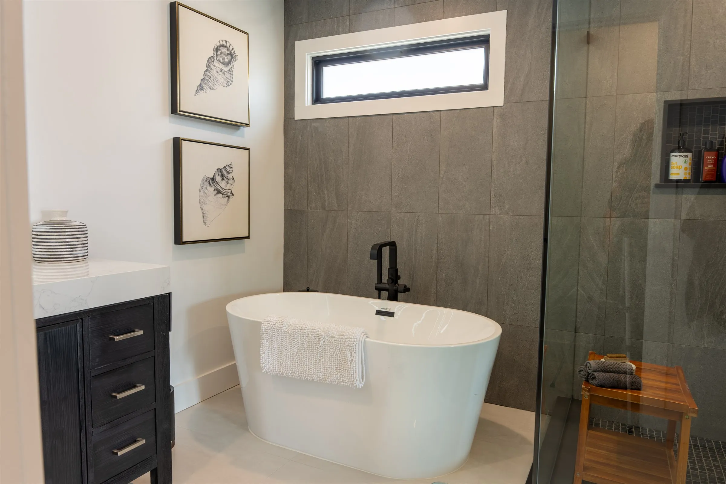 Primary bath with a freestanding soaking tub, framed art, and a glass shower, from Seaboard's Margate, NJ renovation