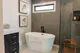 Primary bath with a freestanding soaking tub, framed art, and a glass shower, from Seaboard's Margate, NJ renovation