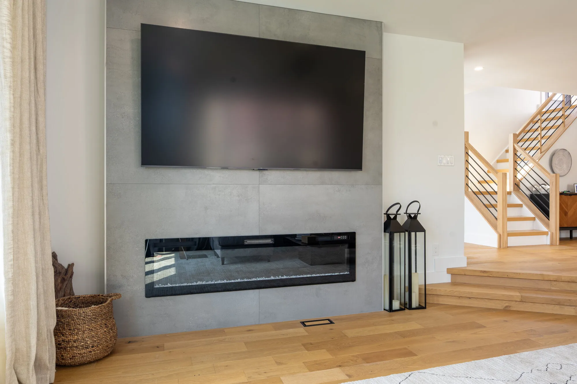 Great room with a linear fireplace, stone surround, and white oak floors from a Seaboard Palm Beach custom home build