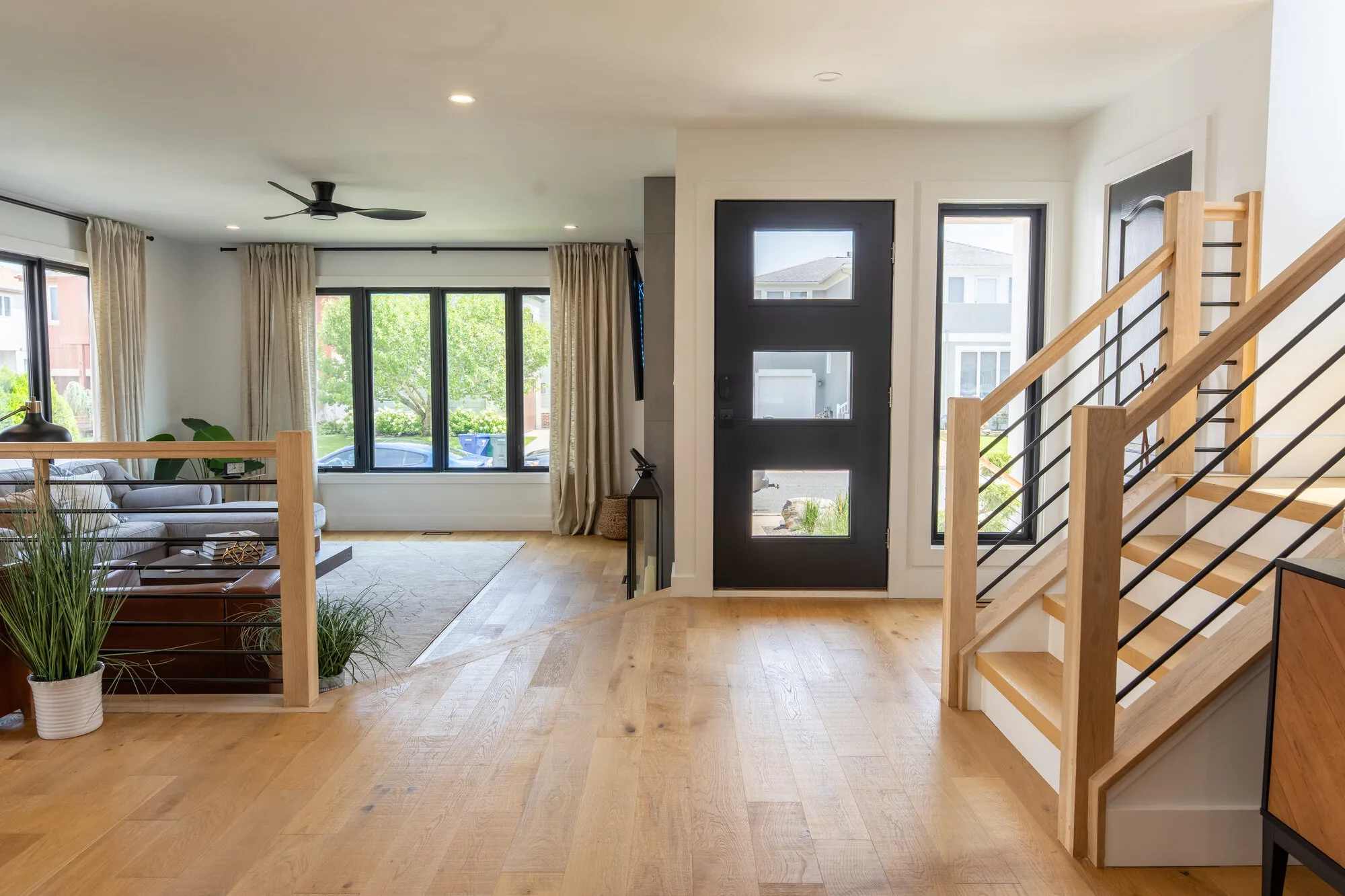 Open-plan living area with white oak floors and an oak stair, the layout Seaboard favors on Singer Island homes