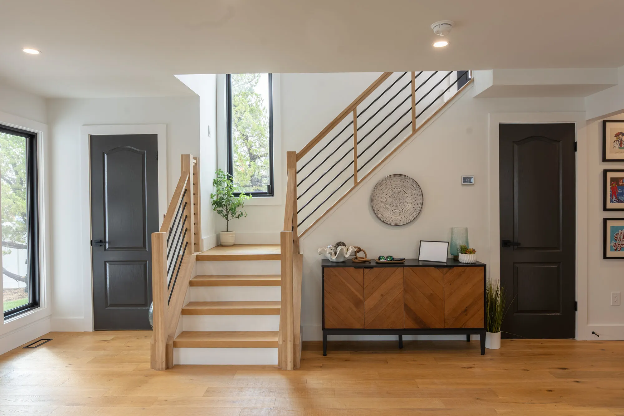 Stair hall with white oak treads and a horizontal metal railing from a Seaboard custom home built for Tequesta
