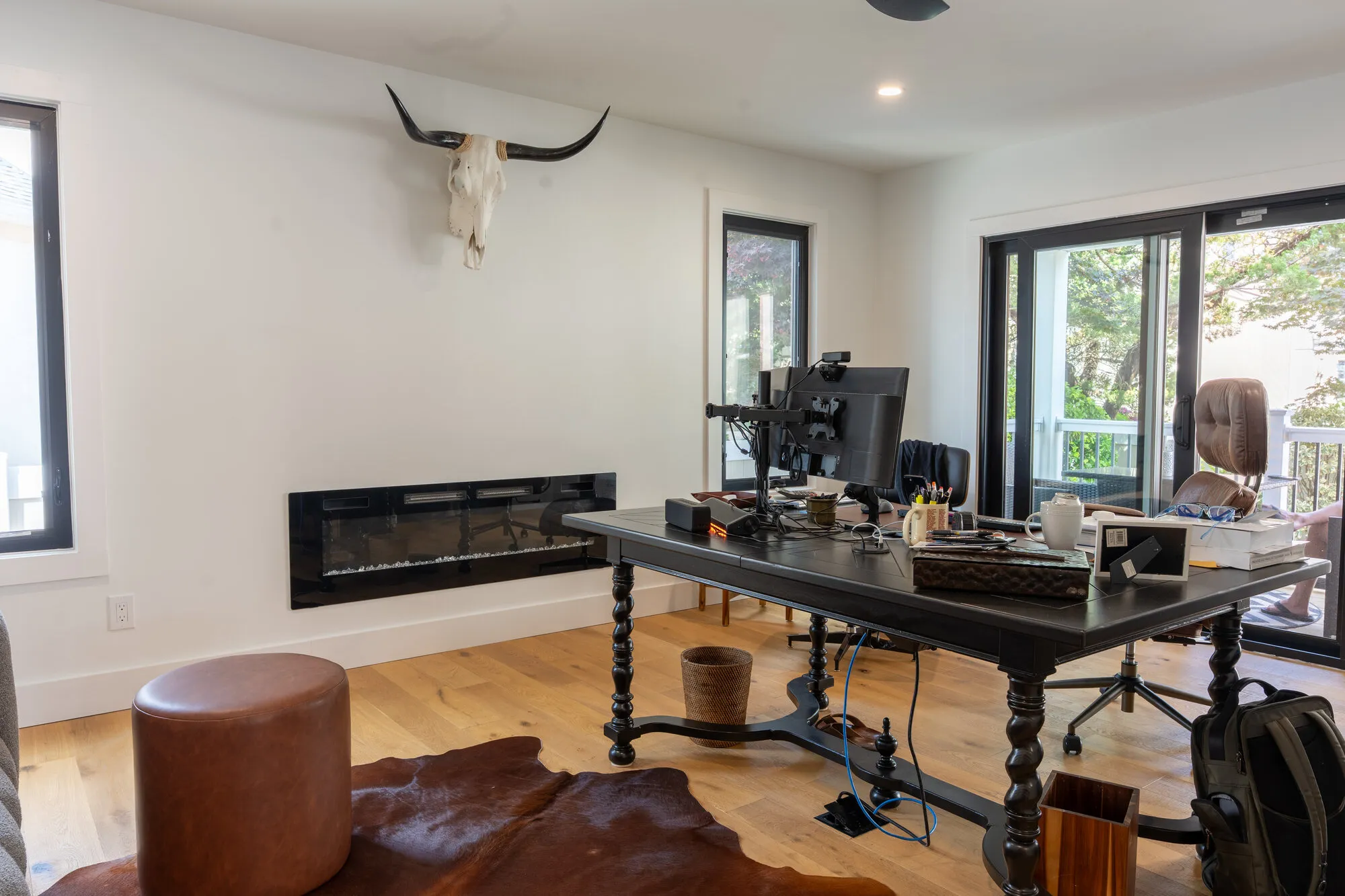 Home office with a linear fireplace and white oak floors from a Seaboard build, a common West Palm Beach renovation scope